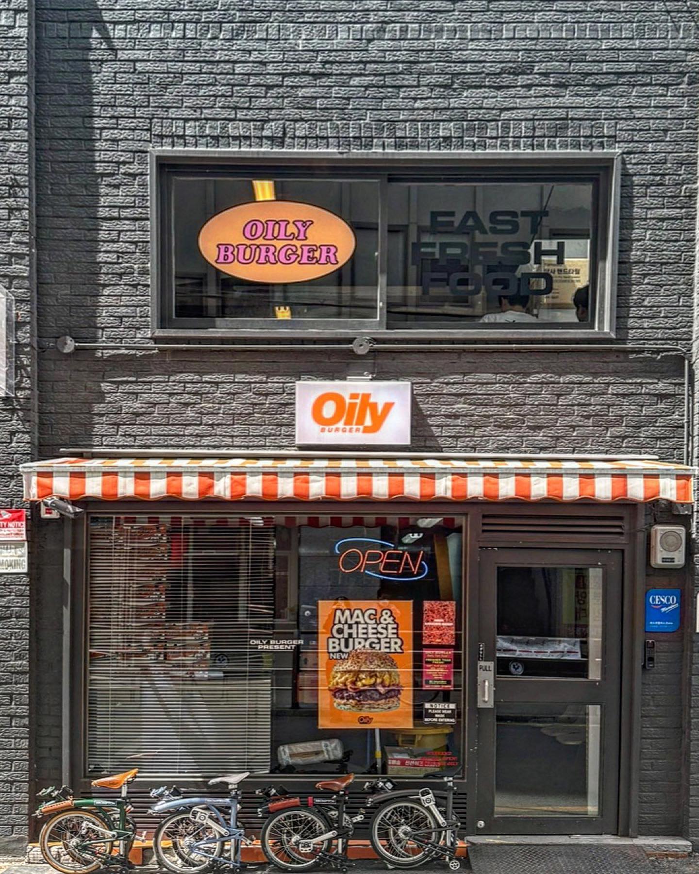 Gyodong flagship — grey brick facade with orange oval sign