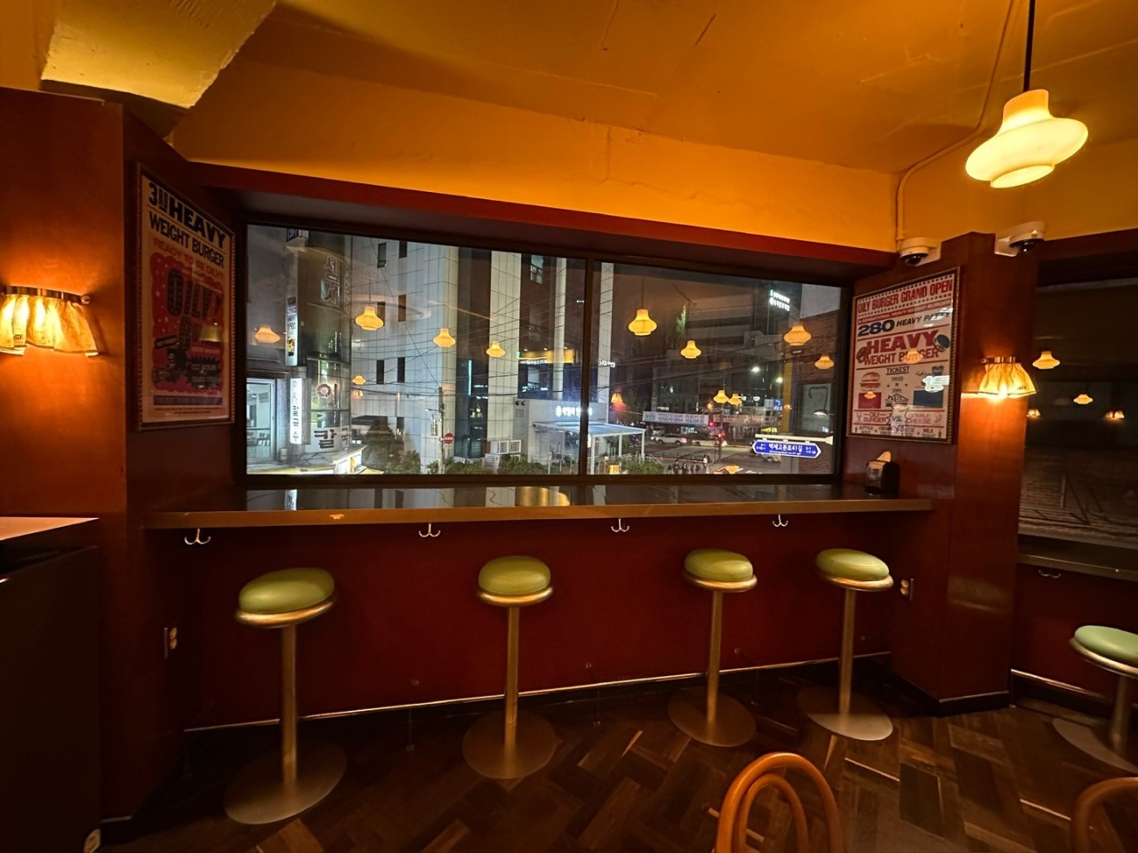 Window bar with green stools over the night city